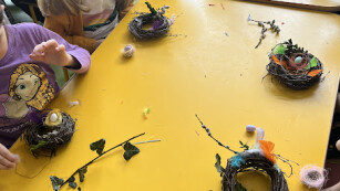 dzieci siedzą przy stole i robią gniazdka