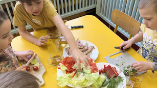 dzieci robią kanapki przy stole