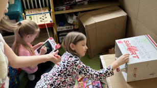 dzieci bawią się w pudełkach na dywanie